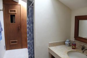 a bathroom with a sink and a shower with a mirror at Puerta del Mar Cozumel in Banco Playa