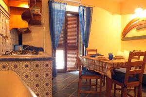 een keuken met een tafel met stoelen en een eetkamer bij Agata di Mare in SantʼAgata di Militello
