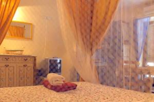 un animal de peluche sentado en una cama junto a una ventana en Agata di Mare, en SantʼAgata di Militello