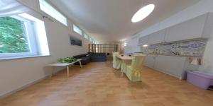 eine Küche und ein Wohnzimmer mit einem Tisch in der Unterkunft Ampio monolocale in villa con giardino in Ischia