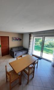 a living room with a table and a couch at Charmante demeure au cœur de la provence verte in Bras