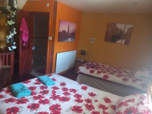 a bedroom with two beds with red flowers on it at Yarm cottages the rafters in Kirk Leavington