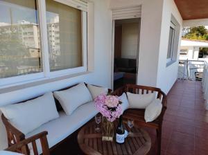 un soggiorno con divano e tavolo con fiori di Precioso piso en playa America con jardin privado. a Nigrán