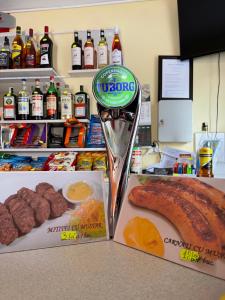 a counter with a table with some food and meats at Motel California in Mărtineşti