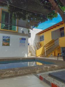 a swimming pool in front of a building with stairs at Momoluu's house in Santa Marta