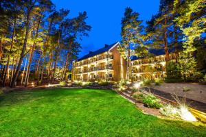 a large yard in front of a building with lights at FORUS apartments in Sventoji in Šventoji