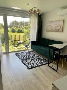 - un salon avec un canapé vert et une table dans l'établissement Mano jūra 2 apartamentai, à Palanga