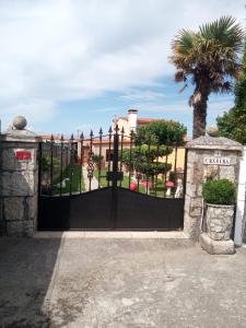 una puerta negra frente a un edificio con una palmera en Casa con jardín en primera línea de playa, en O Grove