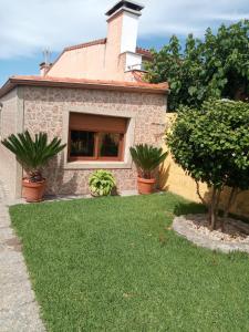a house with a window and some plants in a yard at Casa con jardín en primera línea de playa in O Grove
