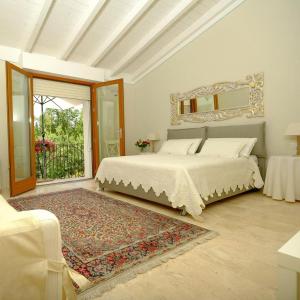1 dormitorio con cama y espejo en la pared en Corte dei Mirti, camere signorili, en Iglesias