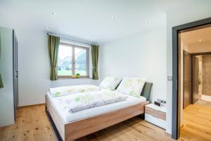 een slaapkamer met een groot bed en een raam bij Landhaus Rosner in Dorfgastein