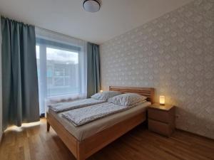 a bedroom with a bed and a large window at Costas apartments in Prague