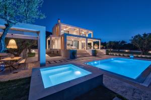 a villa with a swimming pool in front of a house at Delight Luxury Villa - Contemporary Elegance & Tranquility, by ZanteWize in Zakynthos Town