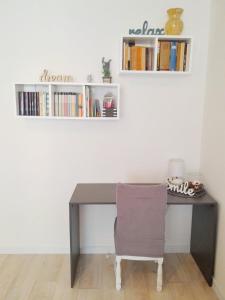 a desk with a chair and books on a wall at Center Flat in Vis