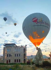 um grupo de balões de ar quente sobrevoando um edifício em Ala Stone Hotel em Goreme