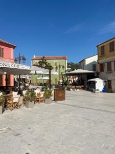 een patio met stoelen, tafels en parasols bij Enea’s guest house in Vlorë
