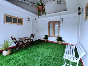 a room with a table and chairs and green grass at The Hilltop Haven in Nainital