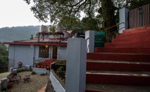 a house with stairs leading up to a building at The Hilltop Haven in Nainital
