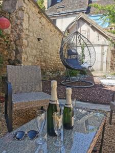 two bottles of wine sitting on a table with glasses at L'Oiseau De La Cathédrale - Calme - Jardin - Wifi in Troyes