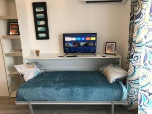 a room with a bed with a television on a wall at Studio en Puerto Norte 4 personas p3 in Rosario