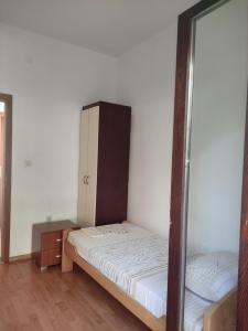 a bedroom with a bed and a dresser and a mirror at Apartments Vukasović in Kotor