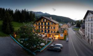 ein Gebäude mit Autos, die vor einer Straße geparkt sind in der Unterkunft Hostel by Grischalodge in Parpan