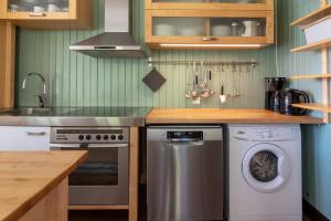 a kitchen with a washing machine and a sink at Feriehus med flott havutsikt ved Hauklandstranden in Leknes