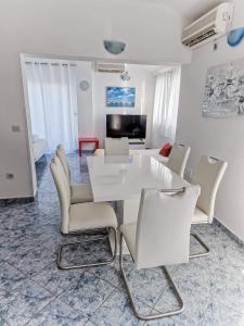 una sala da pranzo bianca con tavolo e sedie bianchi di See paradise a Starigrad-Paklenica (Ortopula)
