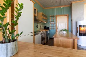 a kitchen with a table with a potted plant at Feriehus med flott havutsikt ved Hauklandstranden in Leknes