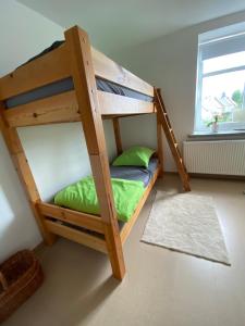 Etagenbett in einem Zimmer mit grünem Kissen in der Unterkunft Geräumige Ferienwohnung im Grünen in Lichtenstein