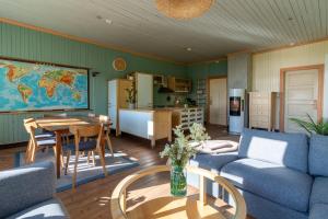 a living room with a couch and a table at Feriehus med flott havutsikt ved Hauklandstranden in Leknes