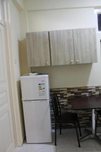 a kitchen with a white refrigerator and a table at Iren Apartment in Batumi