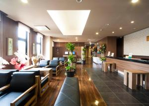 a lobby with a waiting room with couches and plants at Hotel Route Inn Ono in Ono