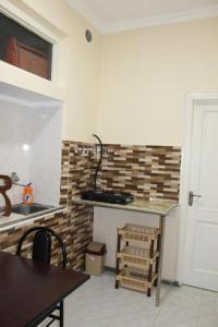 a kitchen with a counter and a sink and a table at Iren Apartment in Batumi