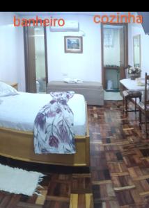 een slaapkamer met een bed en een tafel in een kamer bij Flats Paulo & Neia in Foz do Iguaçu
