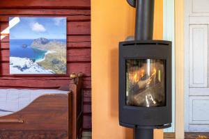 a fireplace in a room with a view of a mountain at Feriehus med flott havutsikt ved Hauklandstranden in Leknes