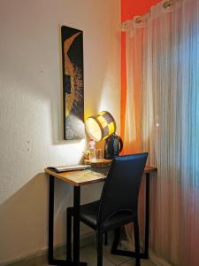 einen Schreibtisch mit einem Stuhl und einer Lampe in der Unterkunft La Maison de Canelya in Cotonou
