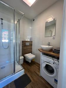 a bathroom with a washing machine and a sink at Apartament Portowa in Kołobrzeg