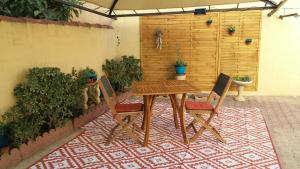 a wooden table and chairs on a patio at la luciole 2 in Canet-en-Roussillon