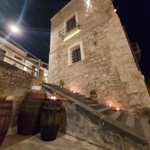 un edificio de piedra con escaleras y luces delante en Sogno e luce, en Racalmuto