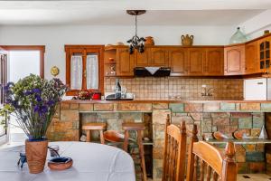 a kitchen with a table with purple flowers on it at Ourania Apartment in Skopelos Town +29 photos