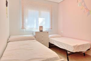 dwa łóżka w pokoju z oknem w obiekcie Casa Felicidad w mieście Calpe +11 zdjęć