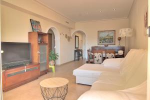 a living room with a couch and a tv at Casa Felicidad in Calpe
