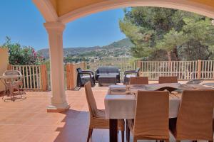 a patio with a table and chairs on a porch at Casa Felicidad in Calpe