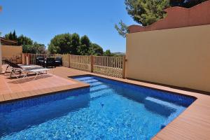 a swimming pool with a table and chairs next to a fence at Casa Felicidad in Calpe