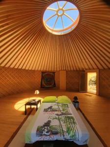 een slaapkamer met een bed in een yurt met een raam bij Yourte contemporaine avec magnifique vue sur les montagnes in Rigarda