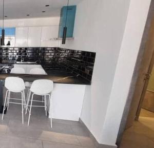 a kitchen with a counter and three stools in it at Luxurious 1 bedroom space in Accra