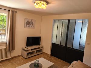 a living room with a flat screen tv and a tv stand at les olivades in Cavaillon