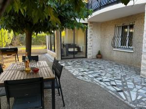 a patio with a wooden table and chairs on a patio at les olivades in Cavaillon