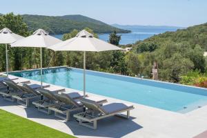 a swimming pool with lounge chairs and umbrellas at Neoma Luxury Residence - Adults Only in Sivota